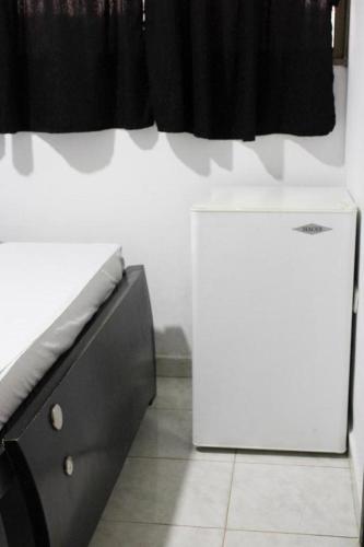een keuken met een koelkast en een zwart gordijn bij Hotel Villa Rocio Curumani in Curumaní