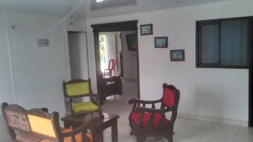 een woonkamer met meerdere stoelen in een kamer bij Hotel Villa Rocio Curumani in Curumaní