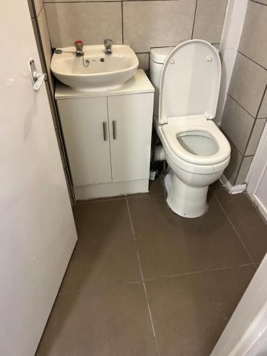 uma casa de banho com um WC e um lavatório em Spacious Comfortable 4 Bedroom House! em Aylesbury