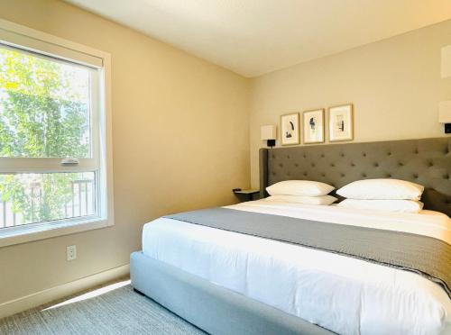 een slaapkamer met een groot bed en een raam bij Joe's Contemporary 2 King Bedrooms Vacation Home in Canmore in Canmore