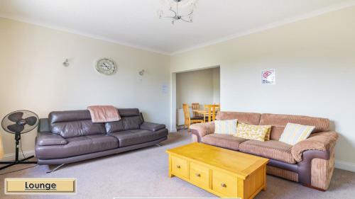 een woonkamer met 2 banken en een salontafel bij Mardon Holiday Home STL Licensed in Inverness