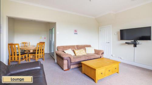 a living room with a couch and a table at Mardon Holiday Home STL Licensed in Inverness