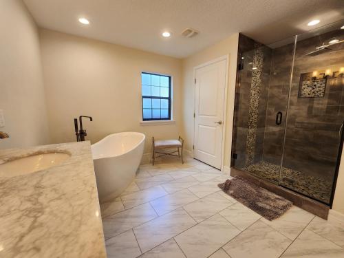 a large bathroom with a tub and a shower at The Villa Orlando@College Park. Sleeps16 in Orlando