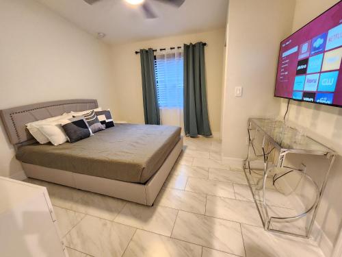 a bedroom with a bed and a flat screen tv at The Villa Orlando@College Park. Sleeps16 in Orlando
