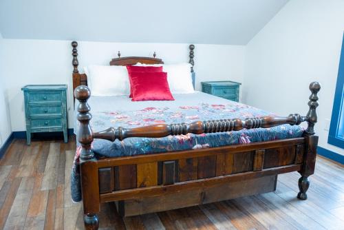 a bedroom with a bed with a red pillow on it at Snodgrass Suite 301, Hyland Hotel in Palmer