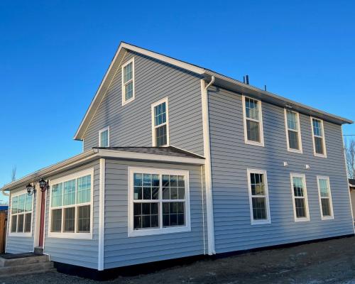 une maison grise avec des fenêtres blanches au-dessus dans l'établissement Snodgrass Suite 301, Hyland Hotel, à Palmer