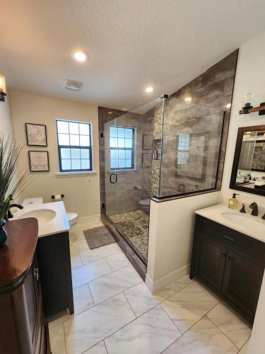 a large bathroom with two sinks and a shower at The Villa Orlando College Park Sleeps16 - Monthly Stays in Orlando