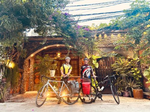 two people are standing next to their bikes at Sầm Sơn Boutique Hotel Phan Thiết in Phan Thiet