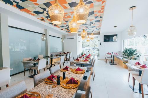 ein Restaurant mit Tischen und Stühlen und einer farbenfrohen Decke in der Unterkunft Paradise Bay Hotel Boutique in Herradura