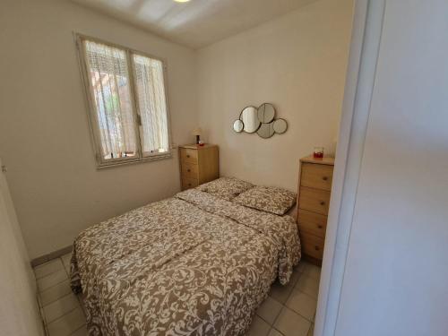 une chambre avec un lit et une fenêtre dans l'établissement Au village naturiste, Villa vue Marina, au Cap d'Agde