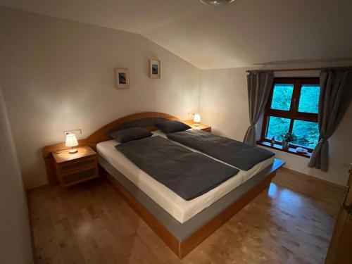 a bedroom with a large bed and a window at Haus am Wald in Marktschellenberg