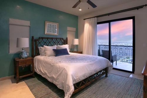 a bedroom with a bed and a large window at Stunning 3BR Condo with Ocean Views, Golf Course & Resort Amenities in Cabo San Lucas