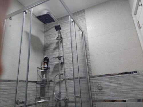 una doccia con una porta in vetro in un bagno di City lux square apartment Skopje a Skopje