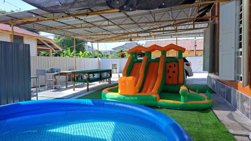 a playground with a slide and a pool at Esah Best INN in Muar