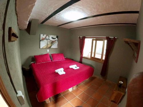 a bedroom with a red bed with towels on it at Finca Momota Salento in Salento