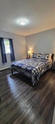 um quarto com uma cama e piso em madeira em Coho Bungalow Ketchikan Alaska em Ketchikan