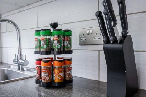 a group of cans of spices on a kitchen counter at Windsor House 3 Bedrooms Sleeps 8 in Manchester