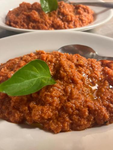 a white plate of food with a dish of food at LOCANDA PODERE LE VIGNE in Radda in Chianti