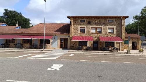 a building on the side of a street with a building with red roofs at Casa Elisa Monegro. in Monegro