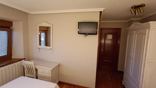 a bedroom with a bed and a tv on the wall at Casa Elisa Monegro. 