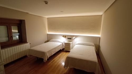 a room with two beds and a light on the wall at Casa Elisa Monegro. 