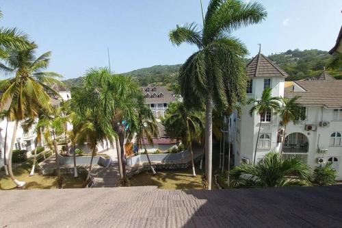a group of palm trees in front of a building at Modern Penthouse @ Sandcastles in Ocho Rios