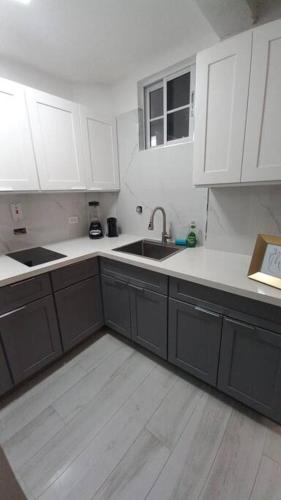 a kitchen with white cabinets and a sink at Modern Penthouse @ Sandcastles in Ocho Rios