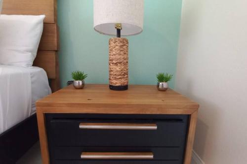 a table with a lamp and two plants on it at Modern Penthouse @ Sandcastles in Ocho Rios