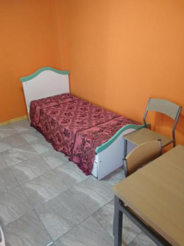 a small bedroom with a bed and a table at Depto Pablo in Olavarría