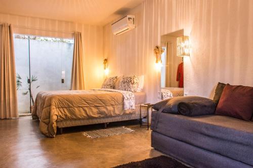 a hotel room with a bed and a couch at Morada dos Saguis in Alto Paraíso de Goiás