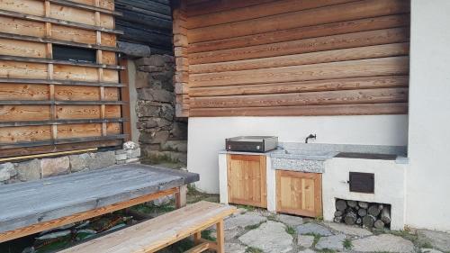 Palù del Fersina的住宿－Alpenchalet Waldl - la Lepre，大楼前的长凳,带烤架