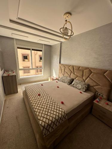 - une chambre avec un grand lit et une fenêtre dans l'établissement Appartement de Lux Hay Al MATAR, à Nador