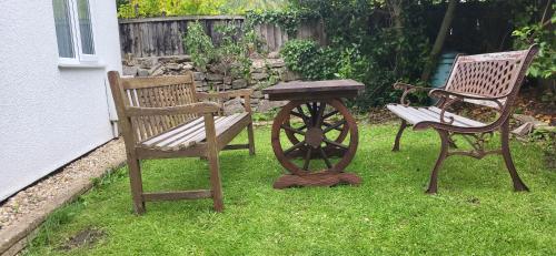 two chairs and a table and a table and a bench at Tivoli Bungalow in Weston-super-Mare