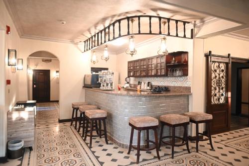 een keuken met een bar met krukken in een kamer bij Eileen Hotel Cairo in Caïro