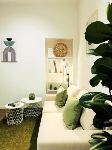 a living room with a white couch and a plant at Tarra Luxury Suite in Milan
