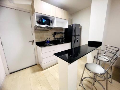 a kitchen with a refrigerator and two chairs in it at Departamento 2do y 3er anillo in Santa Cruz de la Sierra