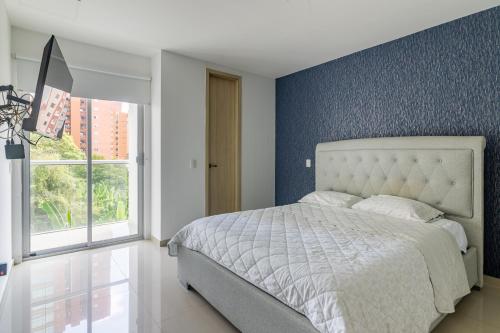 1 dormitorio con 1 cama con pared azul en Habitech soho 55-2 en Barranquilla