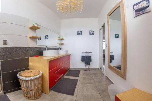 - une cuisine avec une armoire rouge et un miroir dans l'établissement La Villa Mussanda avec piscine, à Baie-Mahault