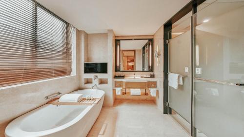 uma casa de banho com uma banheira, um chuveiro e um lavatório. em Yue Yang Hotel em Yueyang