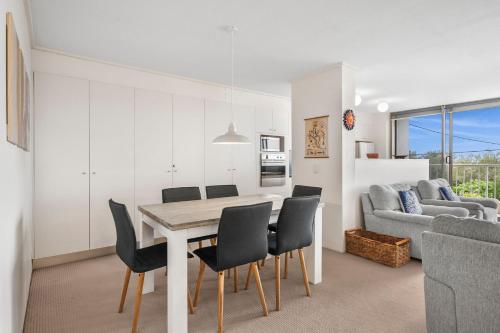 a dining room and living room with a table and chairs at Unit 8 26 Jubilee Esplanade in Yaroomba