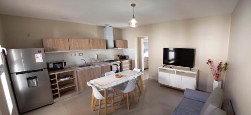 Una cocina con un refrigerador y una mesa dentro. en Bruno`s Haven, en Neuquén
