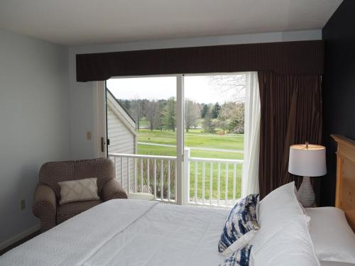 um quarto com uma cama e uma grande janela em The Grand Getaway - Gorgeous And Great Location! em Traverse City