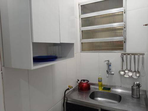 una cocina con armarios blancos y fregadero en Apartamento JM Vista Mar 6, en Río de Janeiro