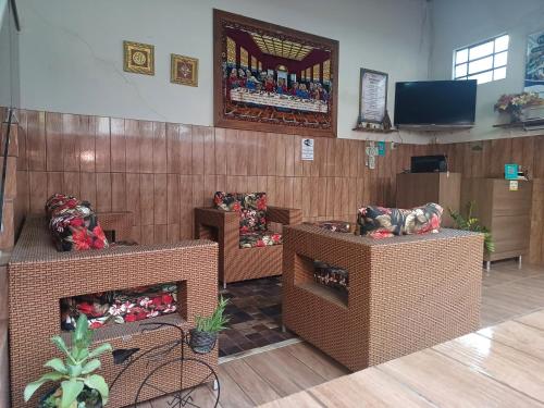 a waiting room with chairs and a tv in a room at Pousada Castro in Aparecida