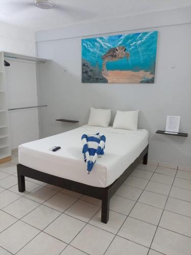 a bed in a room with a painting on the wall at Casa Maria Fernanda in Playa del Carmen