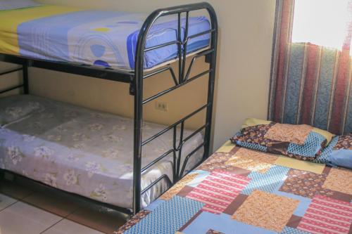 two bunk beds in a room with a quilt at Homestay Matagalpa in Matagalpa