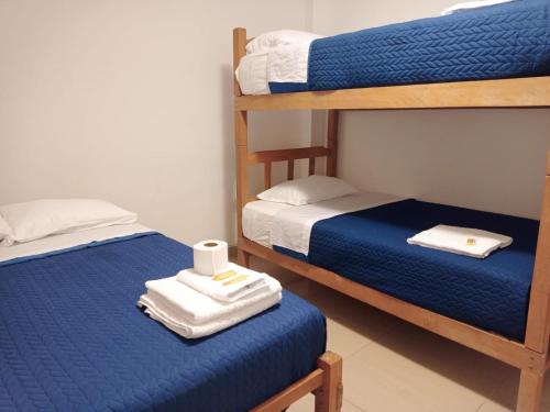 a room with two bunk beds with towels on them at SGH Paracas Hospedaje in Paracas