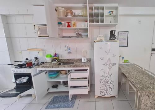 una pequeña cocina con nevera y fregadero en Apartamento Monte Paradiso, en Maceió