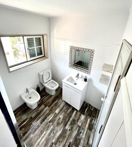 a bathroom with a sink and a toilet and a mirror at Carcavelos Summer Beach in Carcavelos