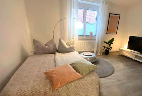 Un dormitorio con una cama grande con almohadas. en ST-Apartment Charming 1 mit Terrasse und Garten, 3 Zimmer in Geislingen, en Geislingen an der Steige